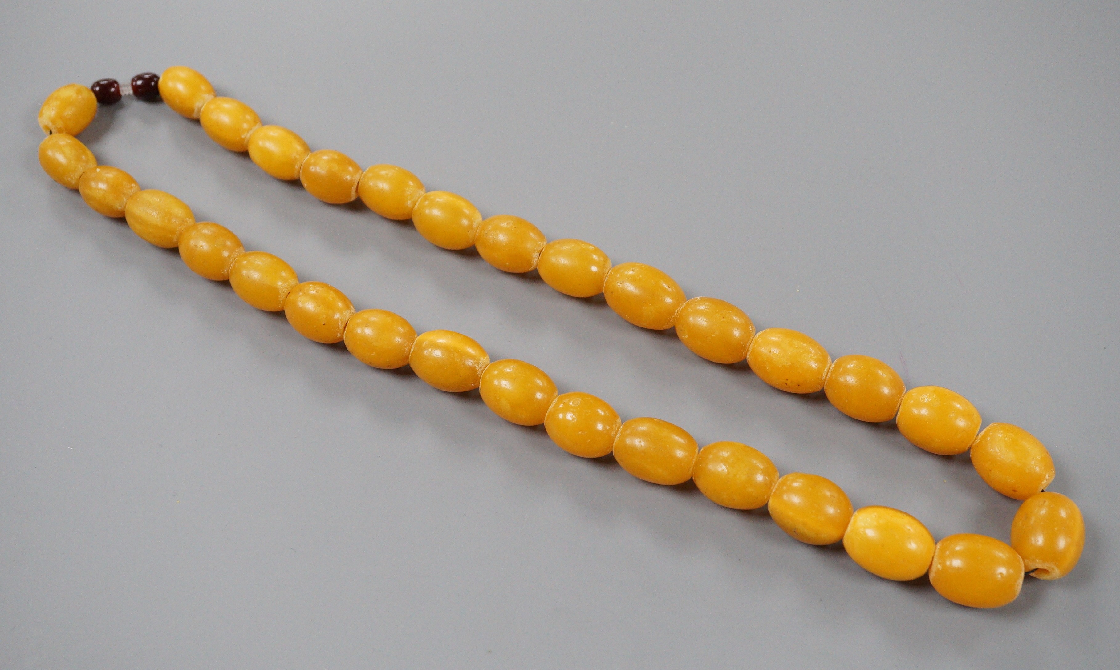 A singe strand oval amber bead necklace, 56cm, gross 68 grams.